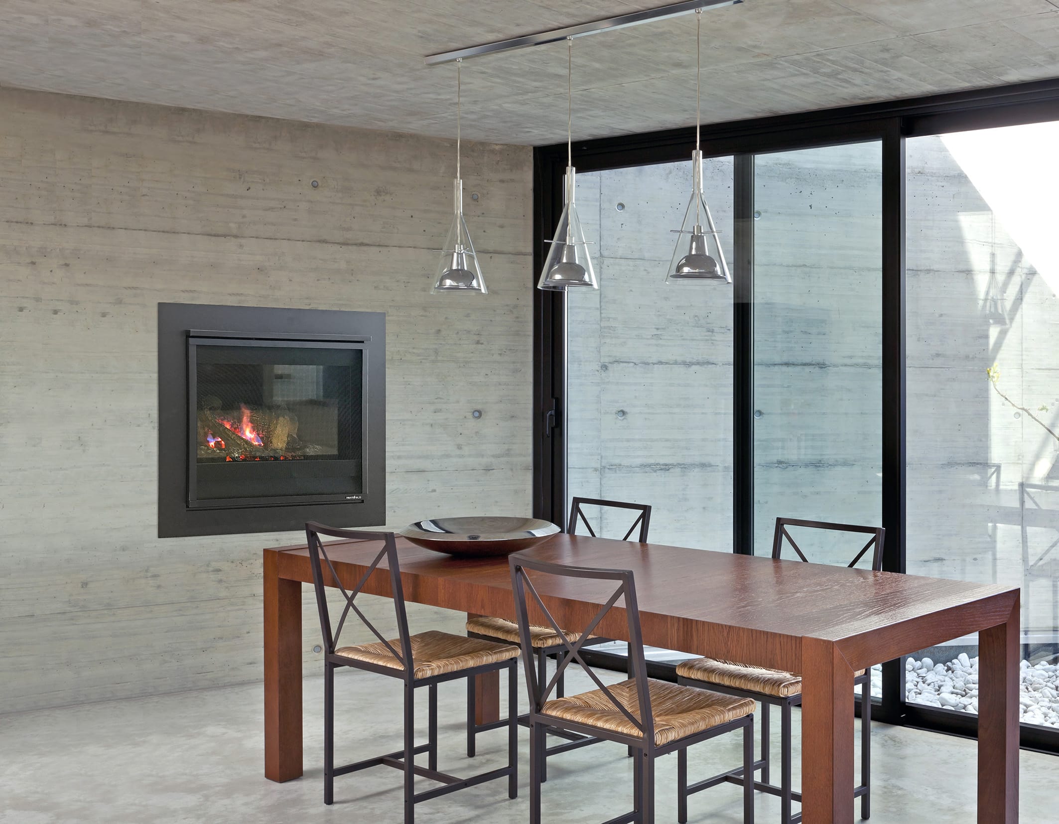 Long narrow wooden table with four chairs next to windows