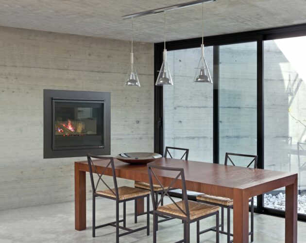 Long narrow wooden table with four chairs next to windows